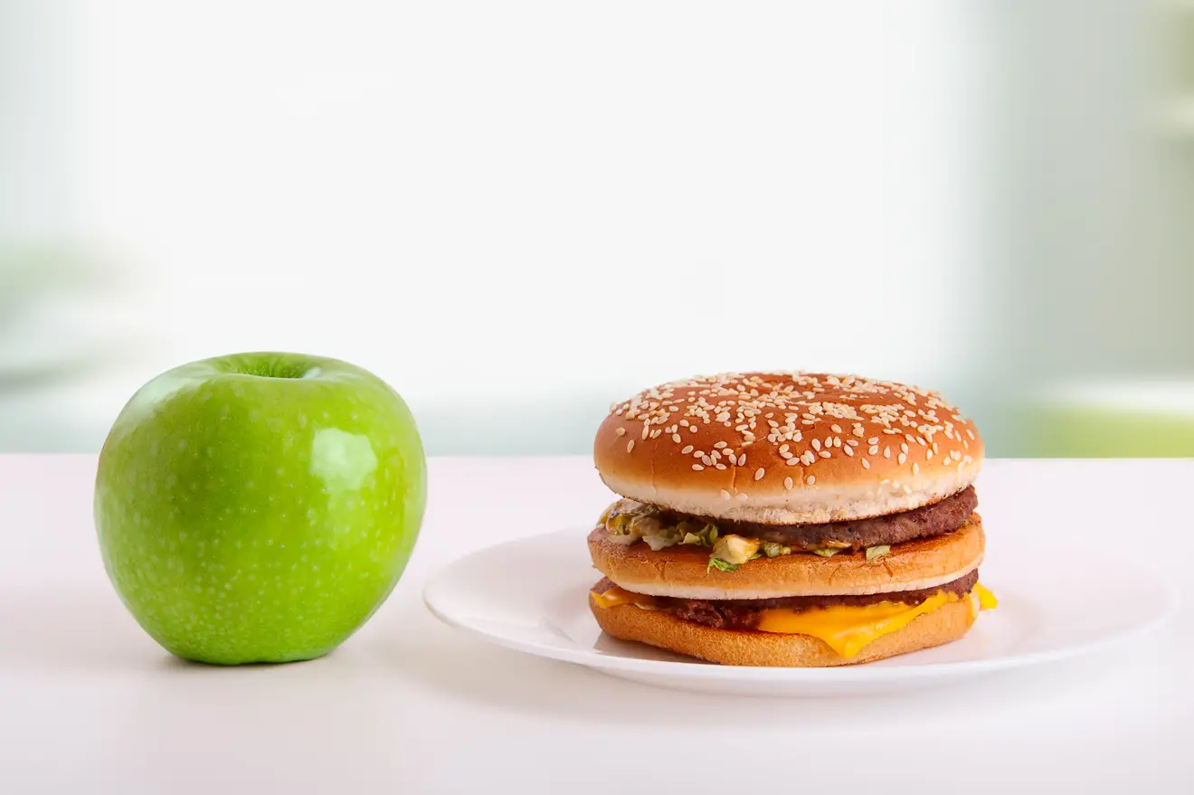 Green apples and Big Mac on table