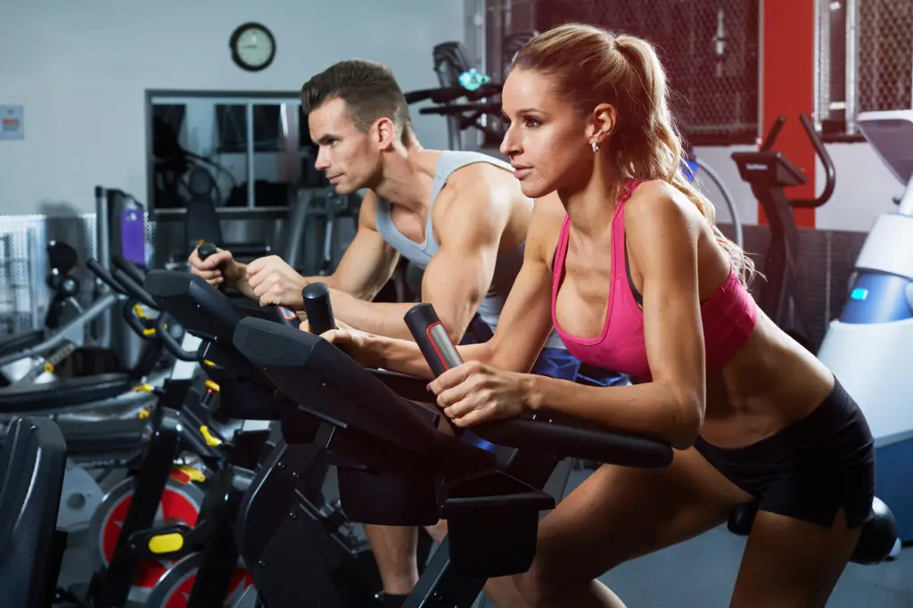 Man and woman on exercises bikes