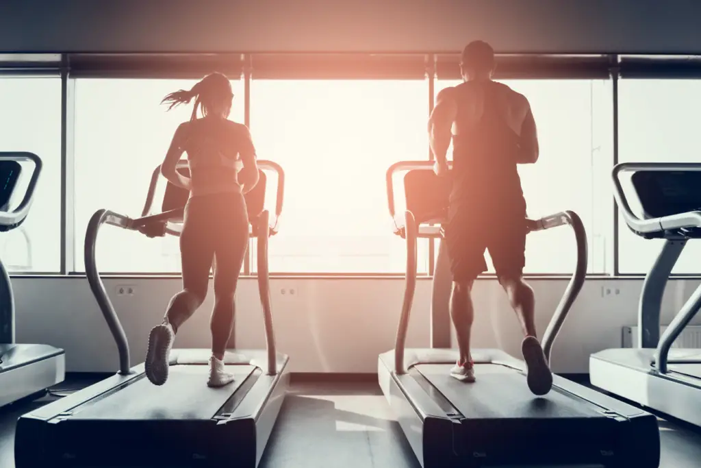 Man and woman running on treadmill