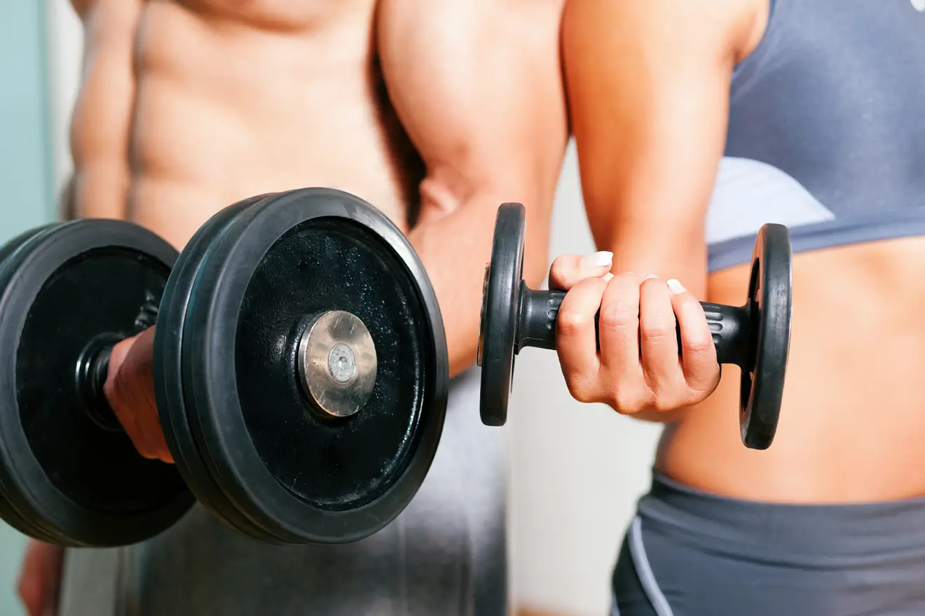 Man and woman holding dumbbells
