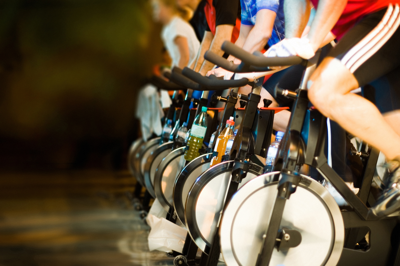 People riding exercise bikes in a gym