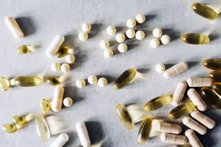Pills, tablets and capsules scattered on a white table