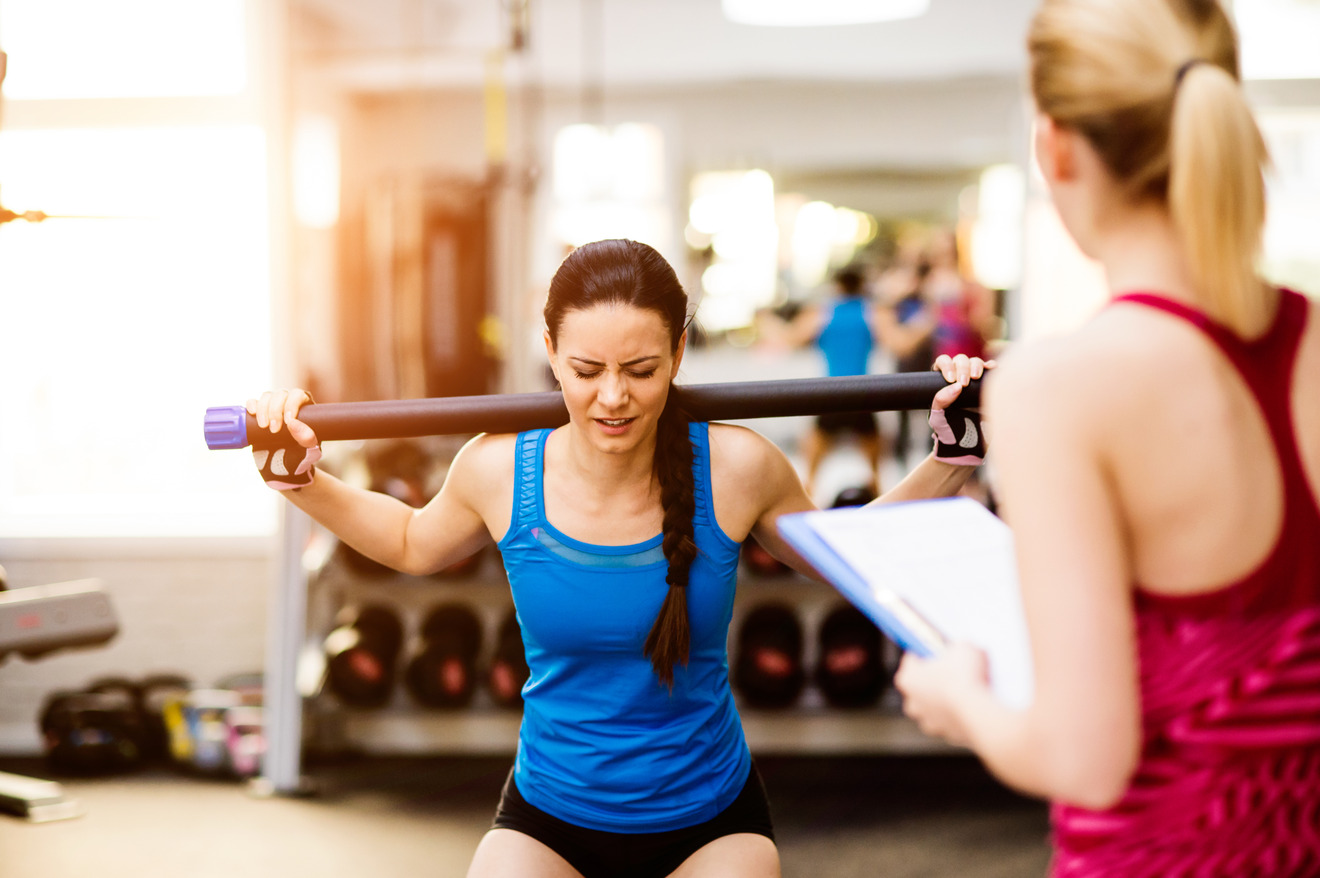 woman struggling to lift a barbell