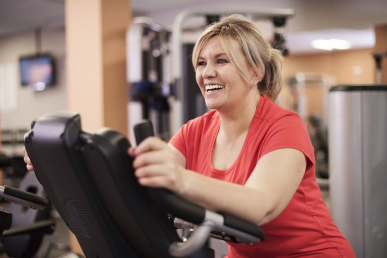 woman working out on a machine with a smile