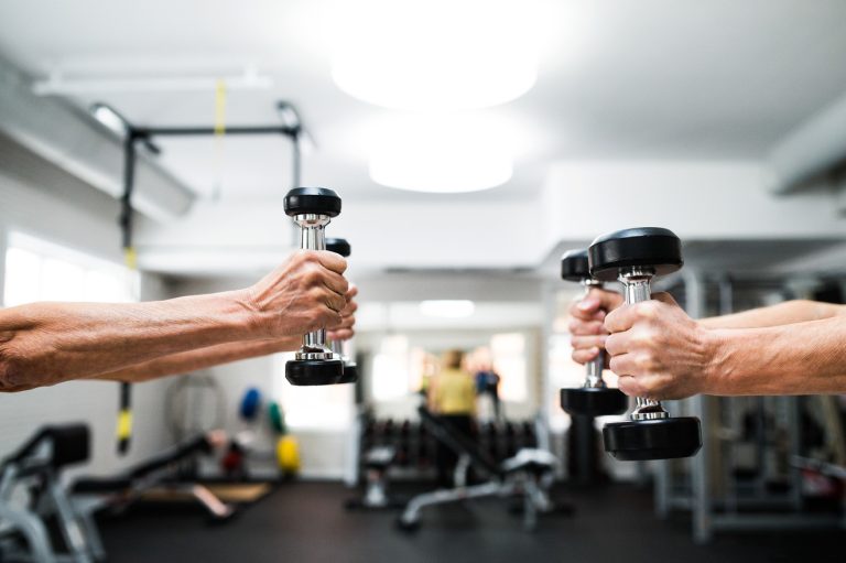 hands on left carrying a small pair of dumbbells and hands on the right carrying a big pair of dumbbells