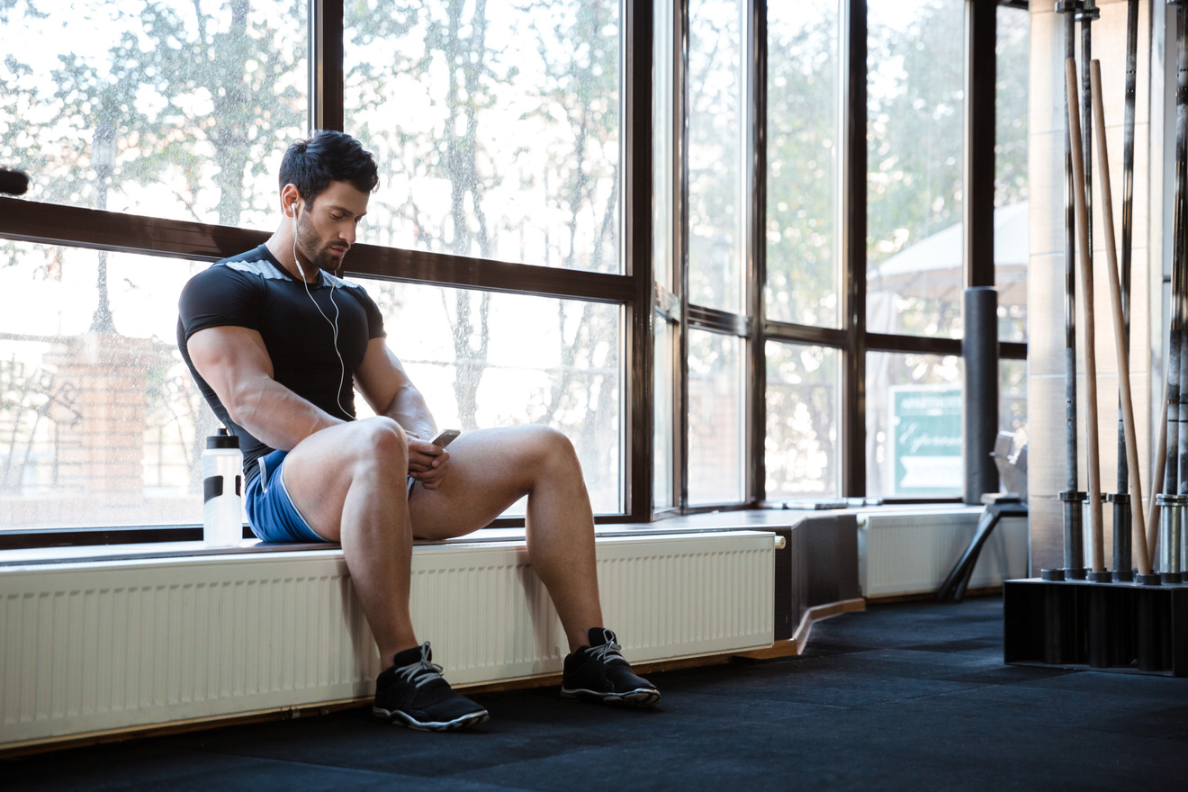 fitness man sitting on the window sill with his head down