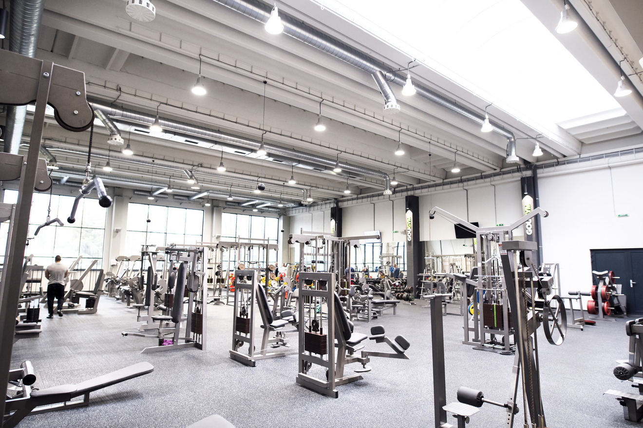 a high-ceiling room full of various gym equipment