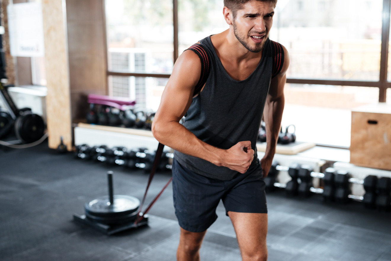 fit man pulling a load while running