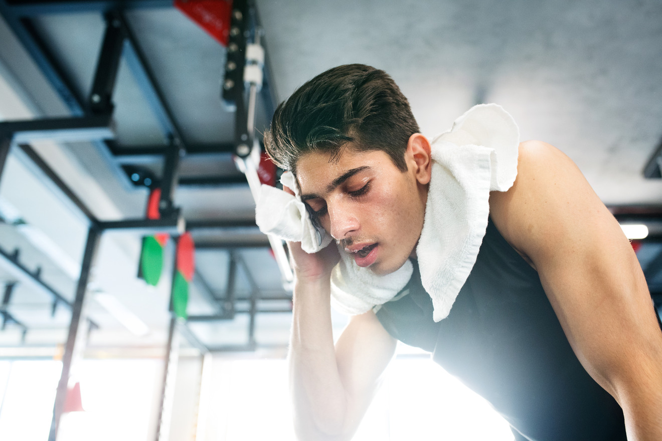 man wiping sweat off his face