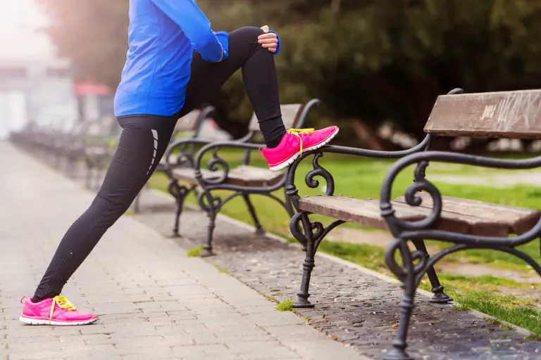 runner doing mobility exercise before running