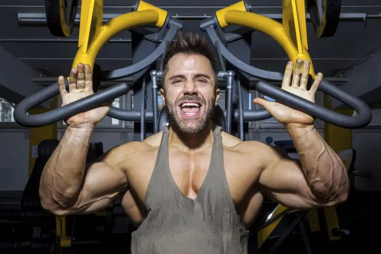 Man in gym doing incline machine chest press to failure