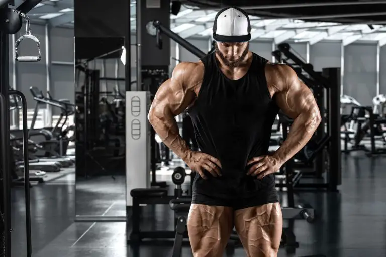 Bodybuilder posing in dark gym