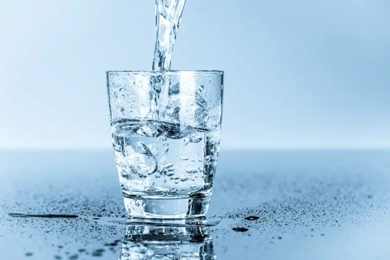 Water pouring into a glass on a table