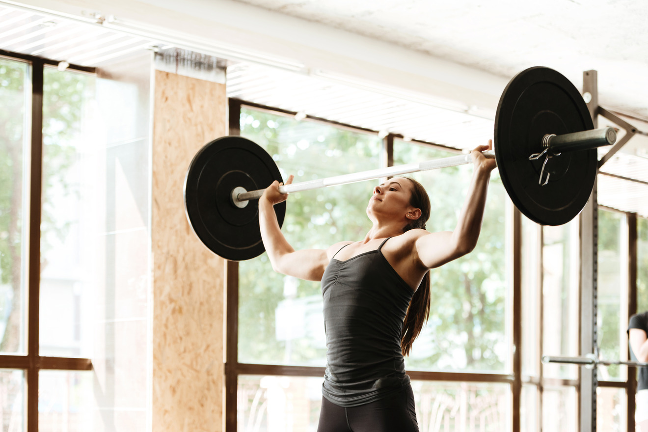 woman lifting a large barbell overhead