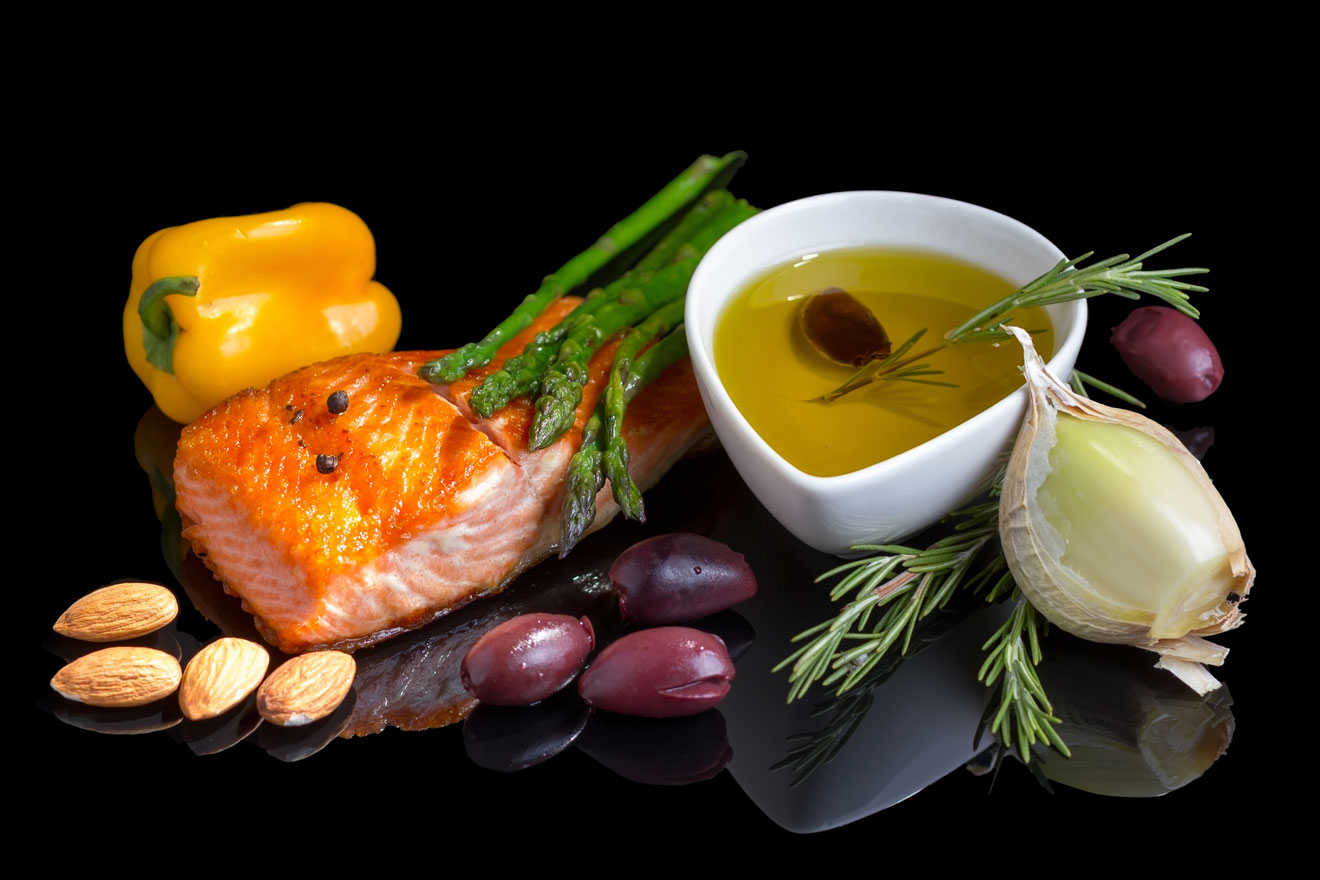 Salmon, almonds, garlic, beans and other superfoods on a black table