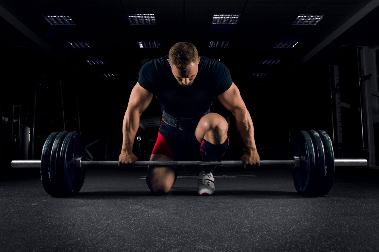 Man in gym preparing to do a deadlift one-rep max or 1RM